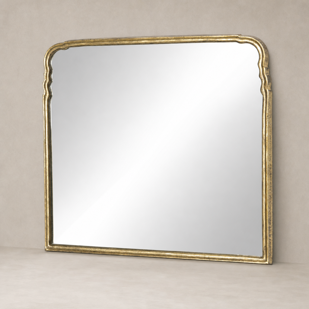 Seine Mantel Mirror with an antiqued gold leaf frame and elegant curved edges.