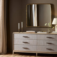 Seine Mantel Mirror in antiqued gold leaf with elegant wavy edges reflecting light.