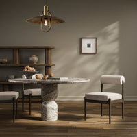 Calista Dining Chair in a cozy dining setting, featuring soft upholstery and sleek wooden legs.