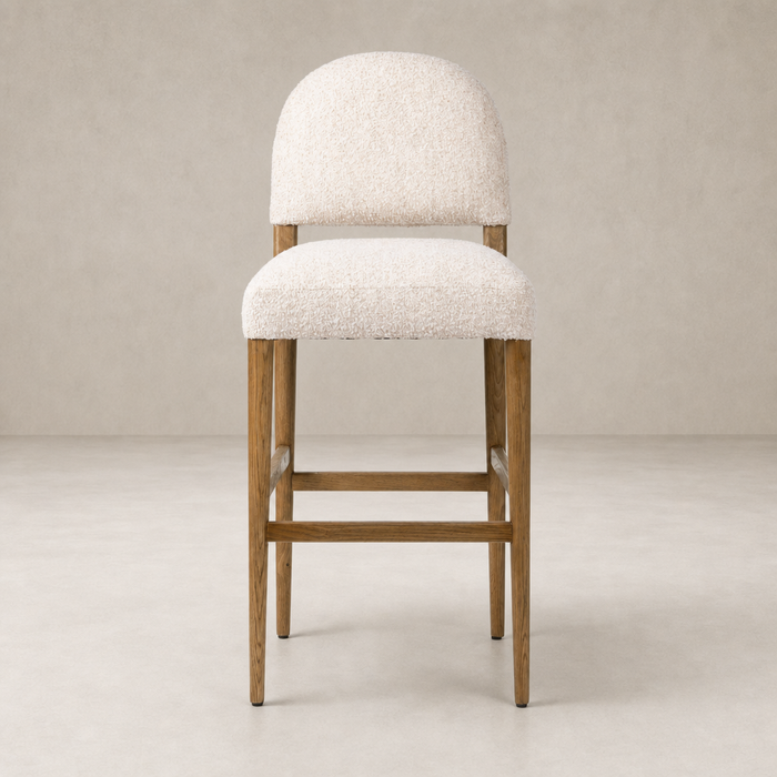 Corinne Bar + Counter Stool in Somerton Ash with soft, textured upholstery and sturdy wooden legs.