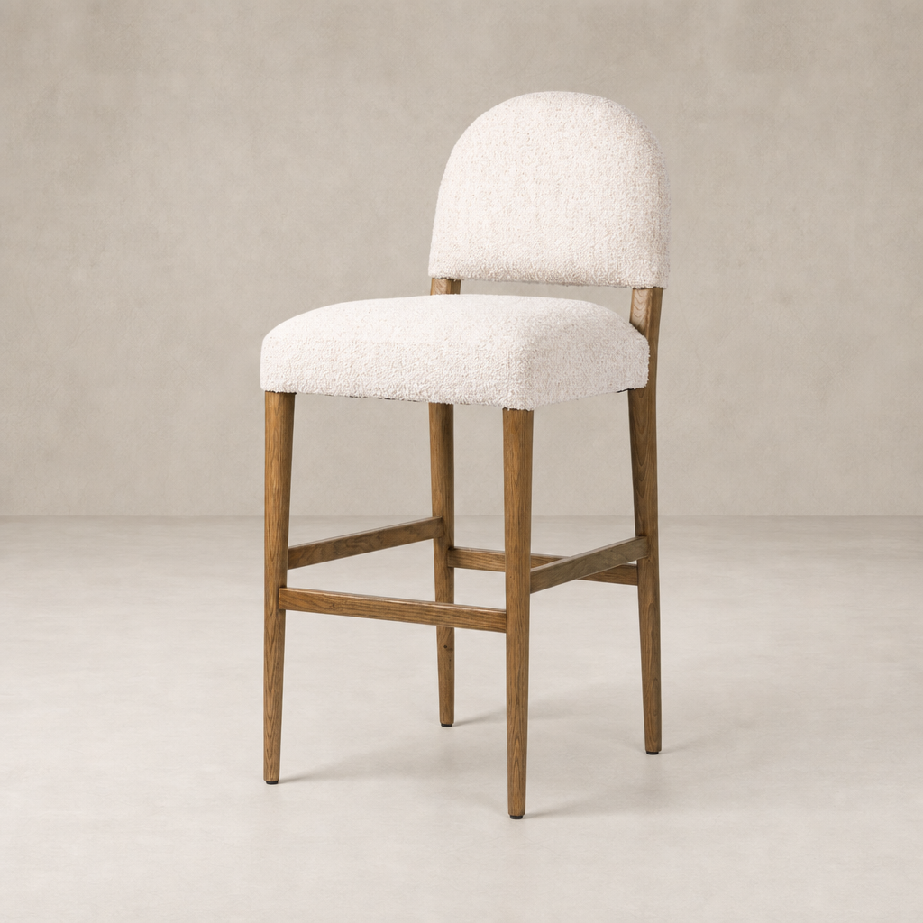Corinne Bar + Counter Stool in Somerton Ash with soft, textured upholstery and wooden legs.