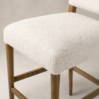Corinne Bar + Counter Stool in Somerton Ash with textured white upholstery and sturdy wooden legs.