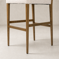 Corinne Bar + Counter Stool in Somerton Ash showcasing wooden legs and cozy upholstery.