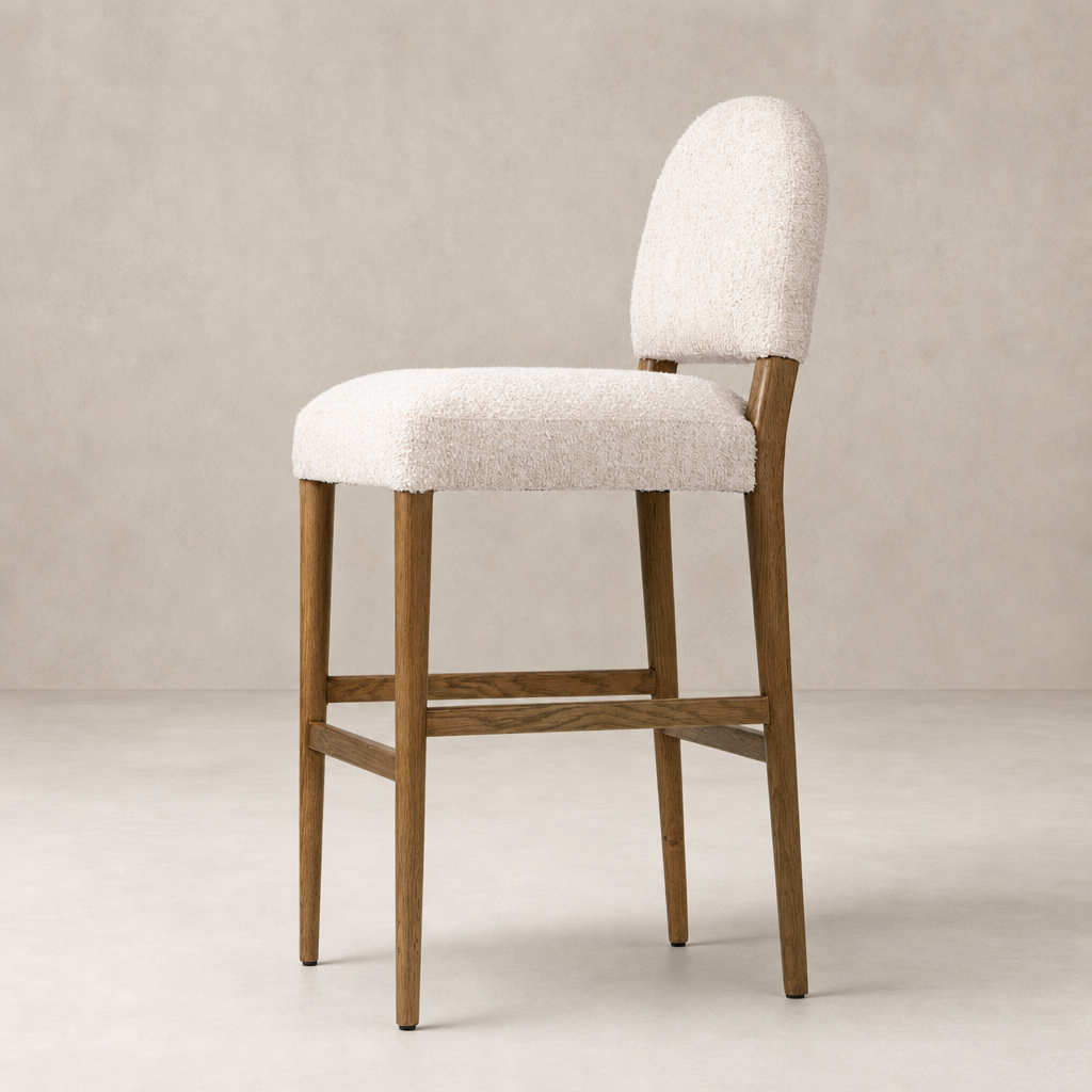 Corinne Bar + Counter Stool in Somerton Ash with soft, textured upholstery and rounded backrest.