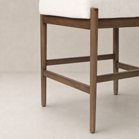 Fern Bar + Counter Stool in Dover Crescent features a textured off-white seat and sturdy wood legs.