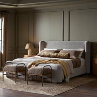Modern bed in Holland Sand fabric, styled with decorative pillows and cozy throws.