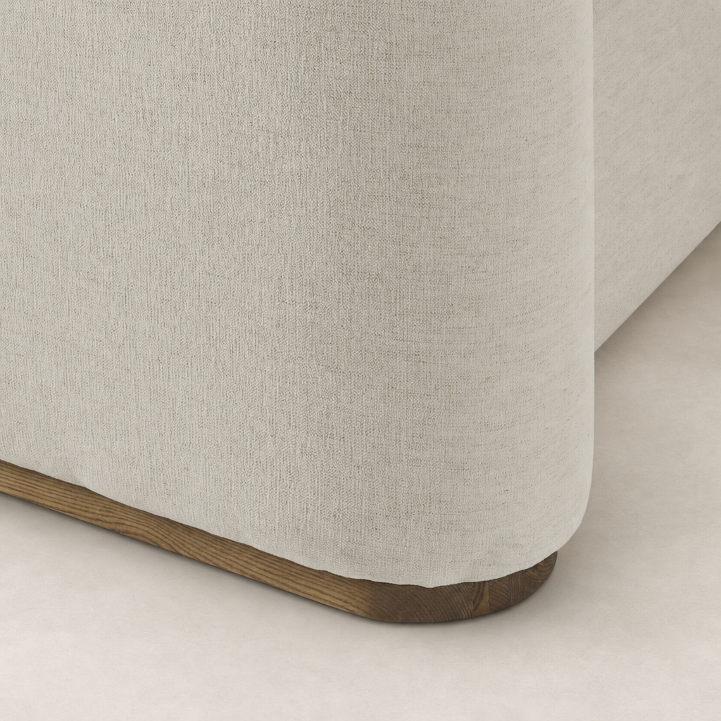 Soft Crypton Nomad Snow bed upholstery with a rounded corner and wooden base.