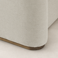 Soft Crypton Nomad Snow bed upholstery with a rounded corner and wooden base.