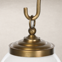 Aged brass iron chandelier with elegant detailing and smooth white glass shade.