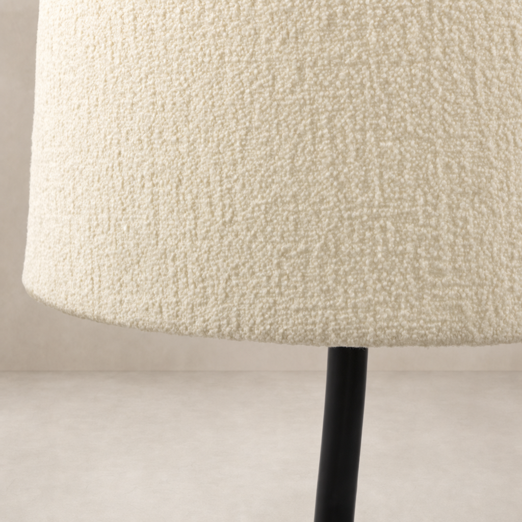 Black wrought iron floor lamp base with soft textured cream shade.