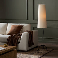 Elegant black wrought iron floor lamp with tapered shade illuminating a stylish living room.