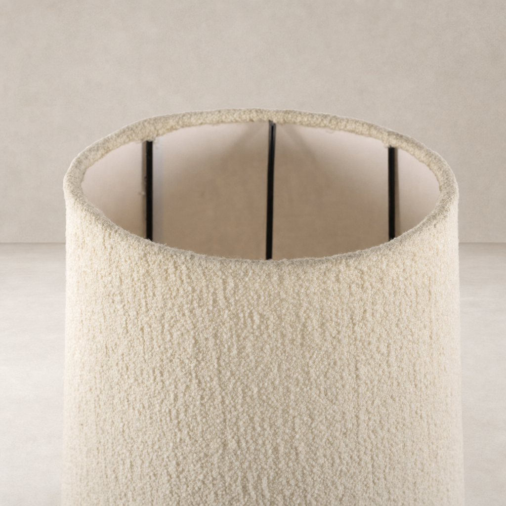 Black wrought iron floor lamp featuring a textured cream shade.
