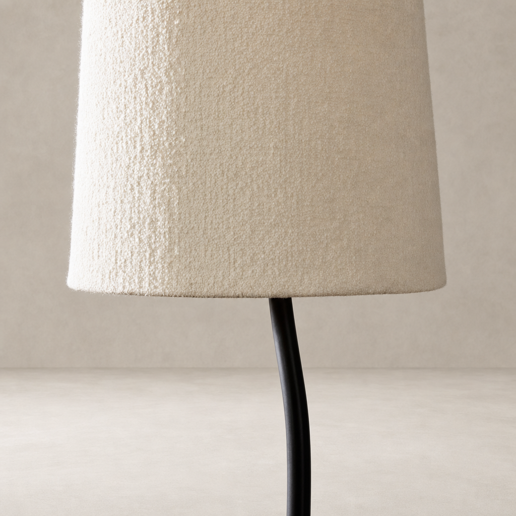 Black wrought iron floor lamp with textured cream fabric shade.