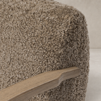 Close-up of Roan Chair's taupe shearling texture and wooden armrest.