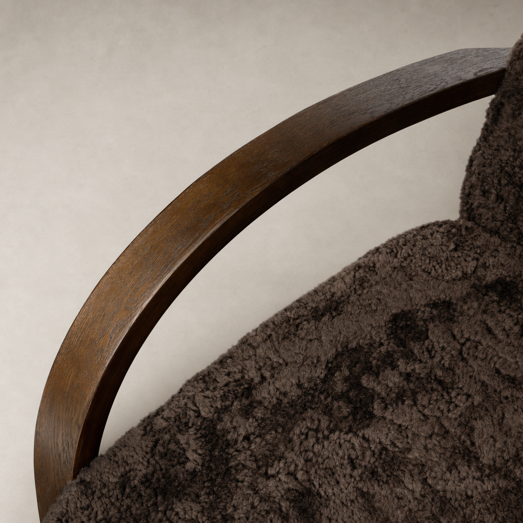 Roan Chair with cocoa shearling upholstery and sleek wooden armrest detail.