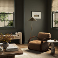 Stylish Roan Chair in amber shearling with curved wooden arms in a modern living room.