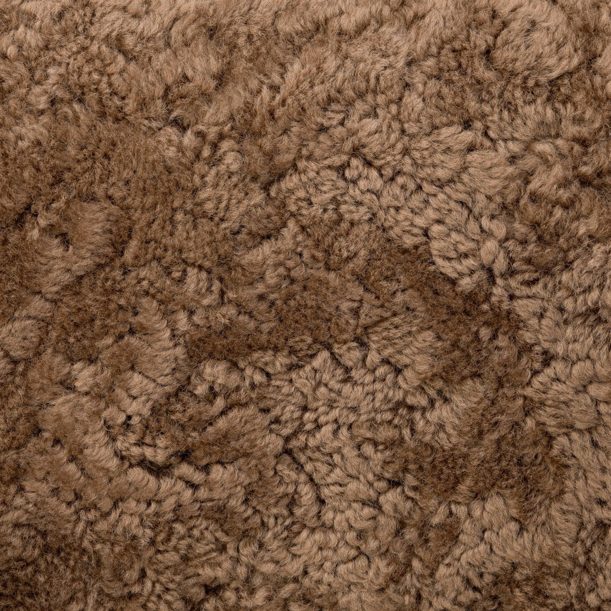 Close-up of the soft, textured amber shearling fabric of the Roan Chair.