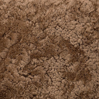 Close-up of the soft, textured amber shearling fabric of the Roan Chair.