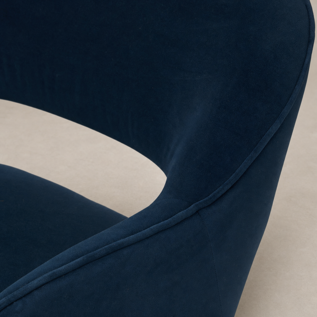 Amira Swivel Chair in Henry Navy showcasing its smooth upholstered fabric and curved design.