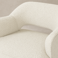 Amira Swivel Chair in natural sheepskin, featuring a plush textured finish and curved design.