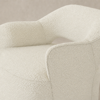 Amira Swivel Chair in Natural sheepskin with plush textured upholstery and curved armrest.