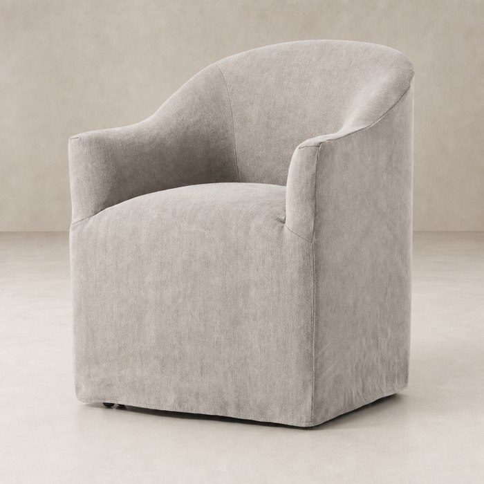 Harbor Dining Chair with Casters in Heather Twill Stone featuring a rounded shape and soft upholstery.
