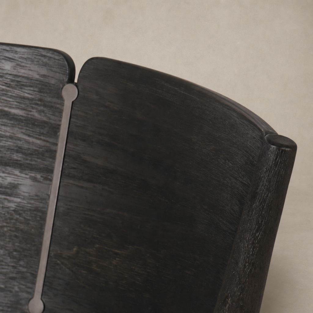 Close-up of Hayes Dining Chair in Antwerp Noir showcasing its sleek wooden finish and curves.