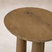 Detail of the Drift Nesting End Table showcasing a round, textured wood top with natural variations.