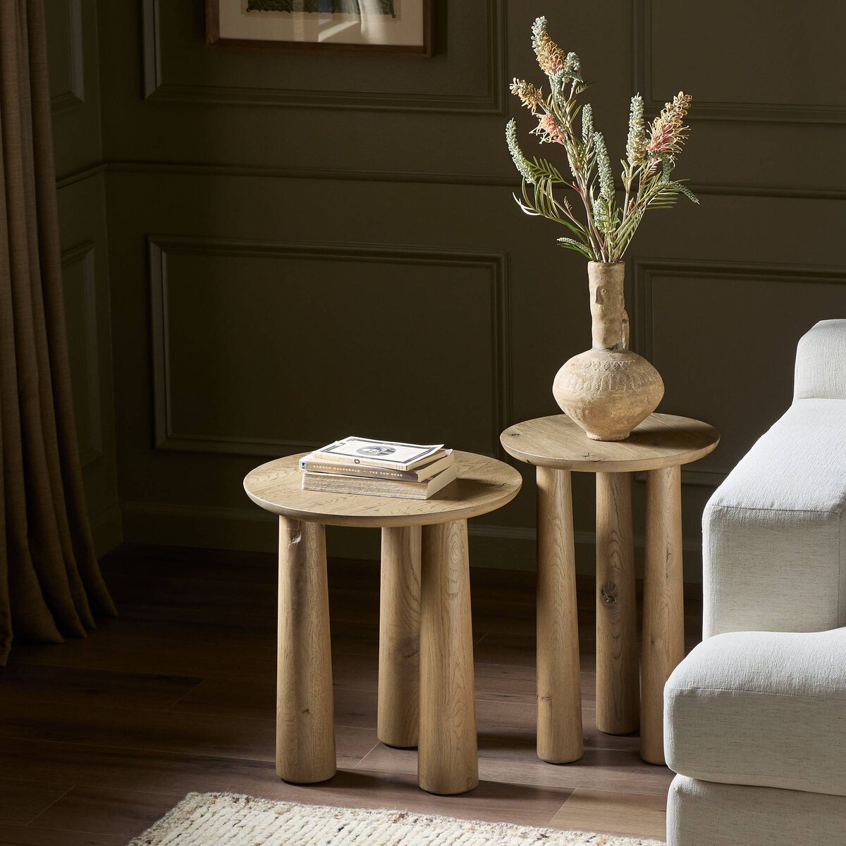 Rustic Drift Nesting End Tables in a cozy setting, featuring rounded tops and sturdy, cylindrical legs.