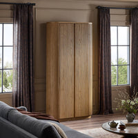 Beatrix Cabinet in Desert Oak featuring a sleek, ribbed design in a cozy living room setting.