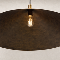 Burnished brass aluminum pendant light with a wide, rounded shade and exposed bulb.