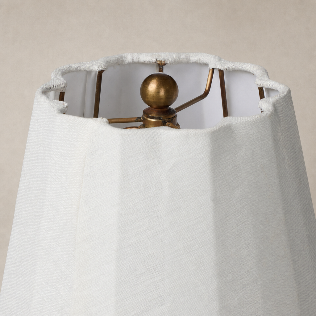Close-up of a matte sage ceramic table lamp shade and metal framework.