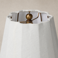 Close-up of a matte sage ceramic table lamp shade and metal framework.