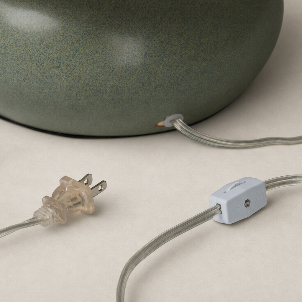 Matte sage ceramic table lamp showcasing a stylish power cord connection.