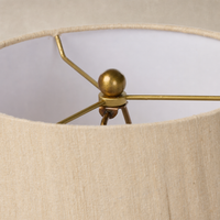 Tan speckled ceramic floor lamp with a modern brass socket and shade detail.