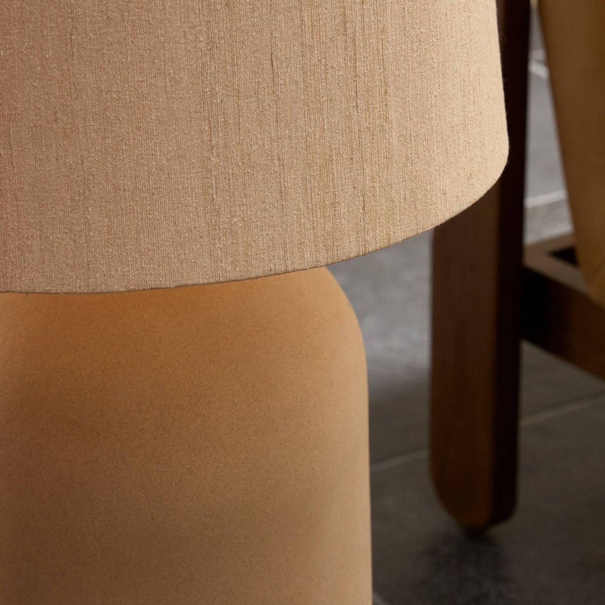 Tan speckled ceramic floor lamp with a textured fabric shade.