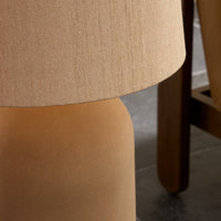 Tan speckled ceramic floor lamp with a textured fabric shade.