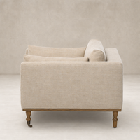 Savannah Chair in Alcala Wheat featuring plush armrests and wooden legs.