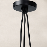 Jet black pendant light with sleek, modern design and multiple hanging cords.