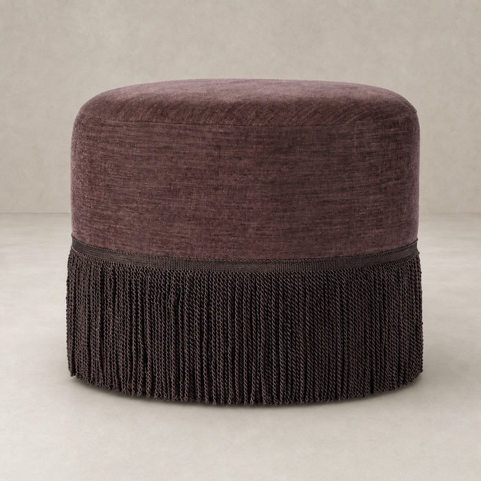 Fringe ottoman in Laughlin Plum with stylish fringe detailing and soft, textured upholstery.