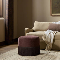 Fringe ottoman in Laughlin Plum with textured fabric and fringe detailing in a cozy room setting.