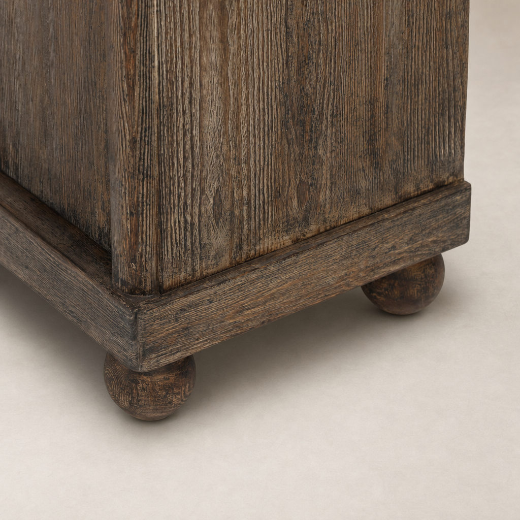 Distressed Cocoa Pine Lisbon Cabinet corner detail showcasing textured wood and rounded feet.