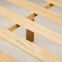 Wooden slats of a sturdy bed frame in light natural finish.