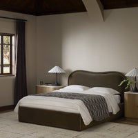 Surrey Olive bed with curved headboard and stylish bedding in a serene bedroom setting.