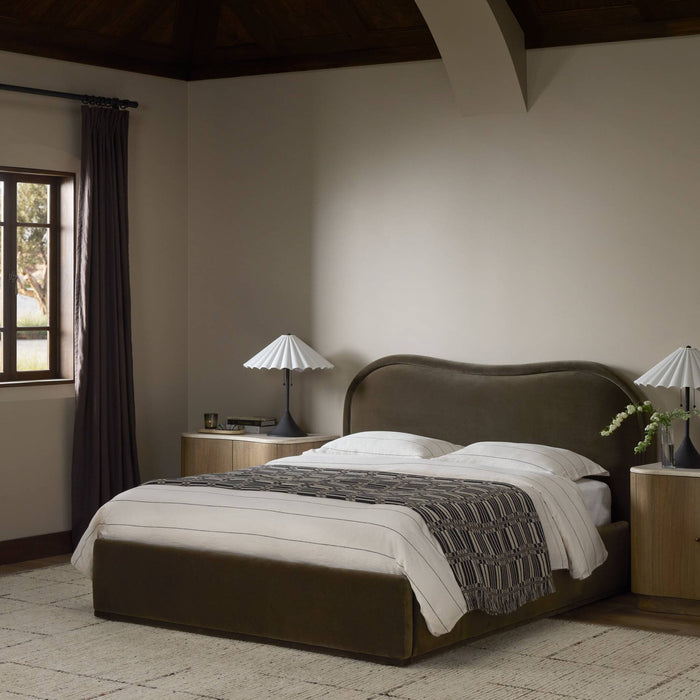 Surrey Olive bed with curved headboard and stylish bedding in a serene bedroom setting.