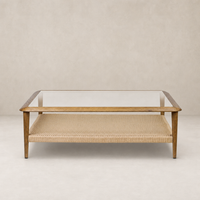 Brandy Coffee Table featuring tempered glass top and natural woven shelf in a modern design.