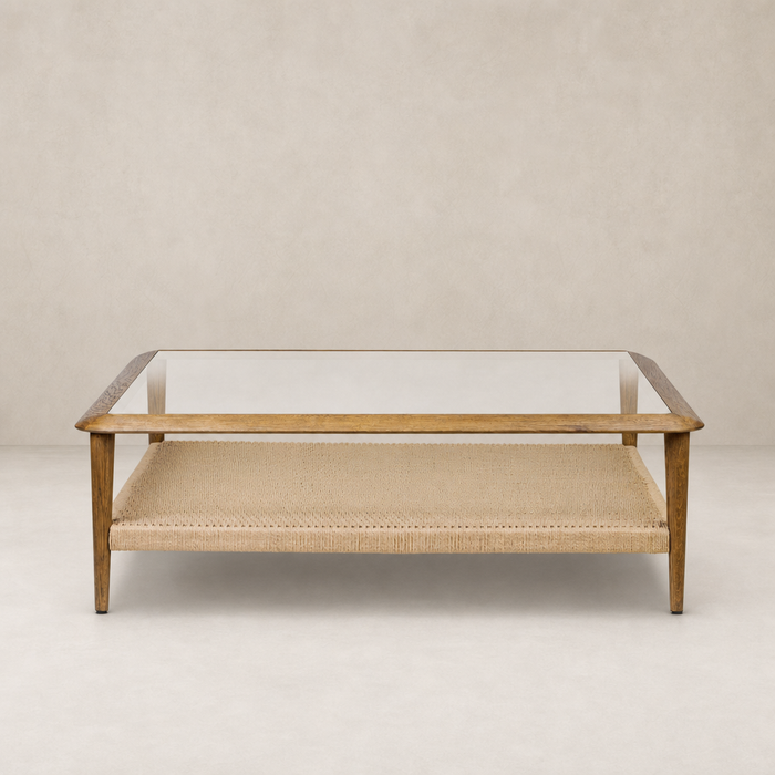 Brandy Coffee Table featuring tempered glass top and natural woven shelf in a modern design.