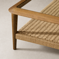 Brandy Coffee Table featuring a tempered glass top and woven natural fiber shelf.