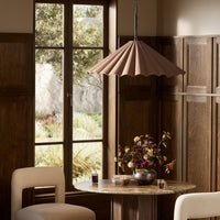 Espresso canvas pendant light with scalloped edges hanging over a rustic dining table.