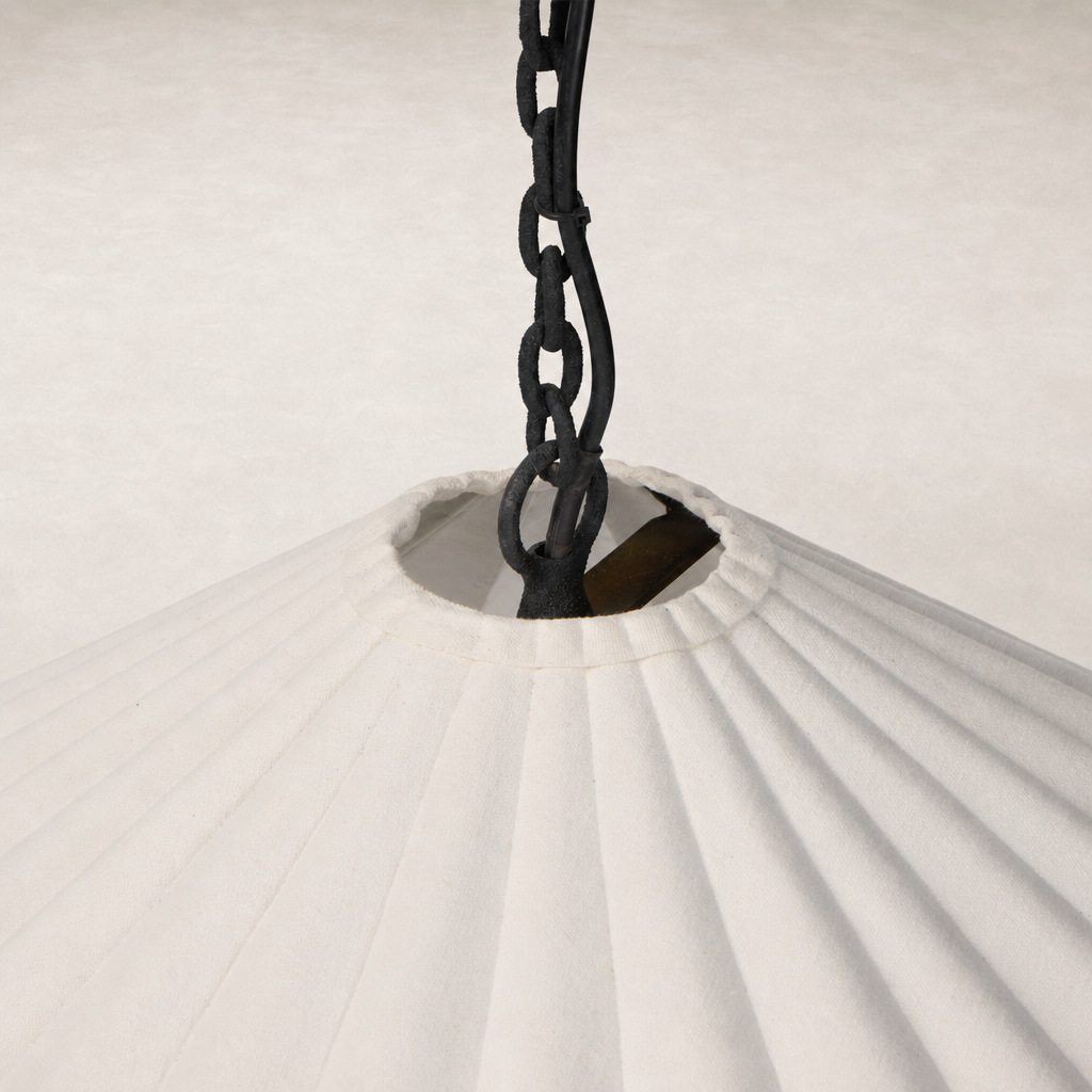Cream canvas pendant light with pleated design and black hanging chain.